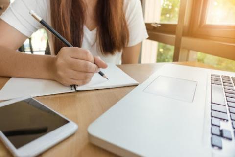 adolescente escribiendo frente a un ordenador